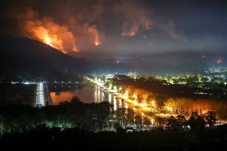 Fire and smoke rise from a forest fire at Nakhon Nayok province, 70 miles northeast of Bangkok, Thailand.