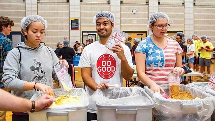Do Good volunteers help pack pre-packaged rice and supplement meals for the needy