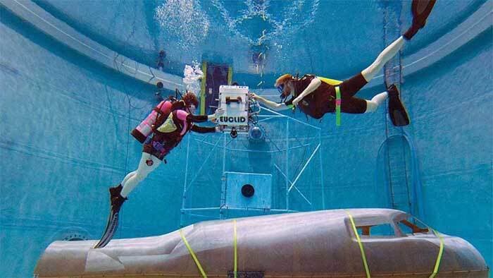 Scuba divers in the Campus diving pool practice drills with the mockup of an aircraft